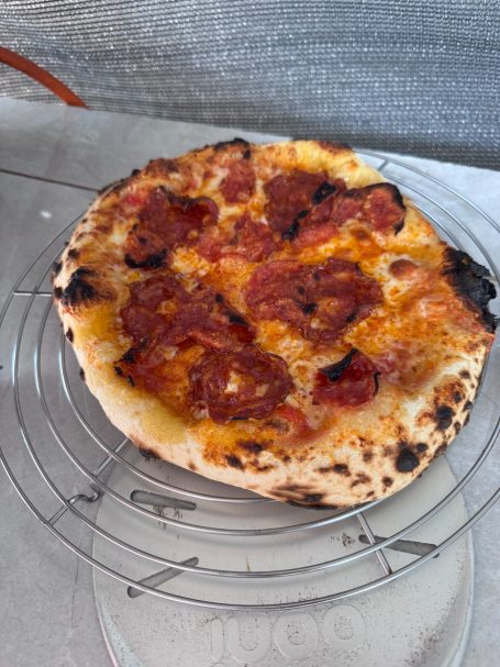 Pizza mit knusprigem Rand und schmelzendem Käse, belegt mit Tomatensauce und Schinken.